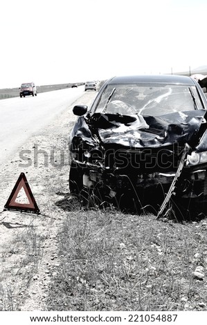 accident car and warning triangle beside road 