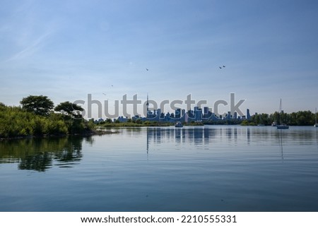 cityscape - silhouettes of skyscrapers, calm lake, forest and yacht. Blue tone