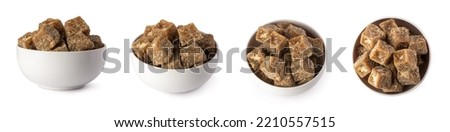 set of jaggery pieces in a bowl, golden brown colored cube shaped unrefined sugar product also called kithul jaggery or palm sugar, traditional food in southeast asia, on white background Royalty-Free Stock Photo #2210557515
