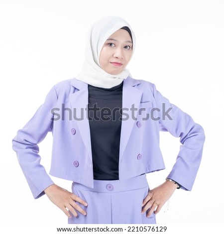 Young beautiful Asian Islamic businesswoman wearing hijab holding a tablet . Confident Muslim woman poses strongly and confidently. Women empowerment and leadership concept. Isolated on white
