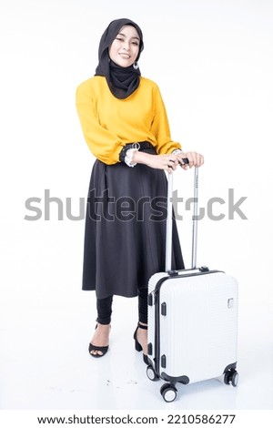 A traveling Asian Muslim woman wearing hijab with luggage bag for a trip. Isolated on white background