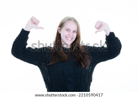 Young happy proud blonde woman showing thumb up on white background 