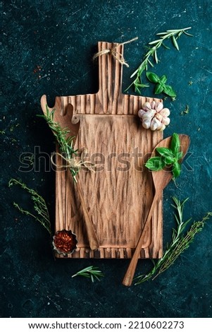 Kitchen old wooden board, free space for text. On a black stone background. Top view.