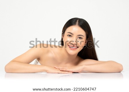 Beauty shot portrait of smiling beautiful young Asian woman in white studio background for skin care concept