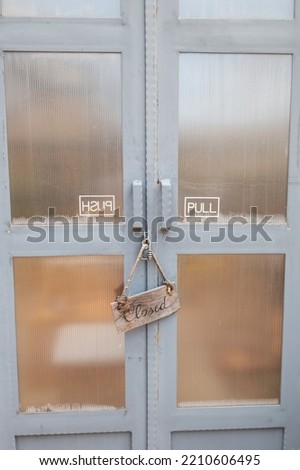 The wooden sign hangs on the rope to close the shop in front of the door.