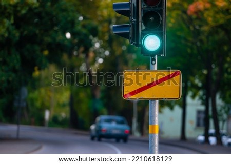 traffic semaphore with green light on defocused background of autumn city, close-up