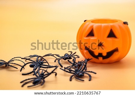 close-up halloween pumpkin with spiders on orange background