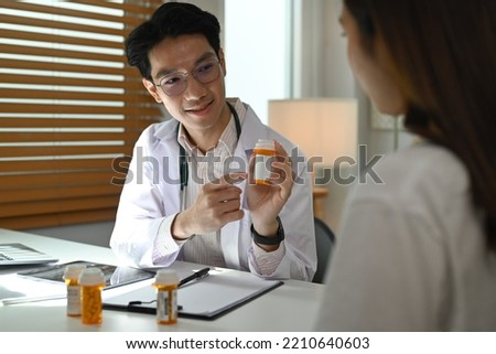 Smiling doctor explaining medicine dosage to o patient. Medicine, healthcare and people concept 
