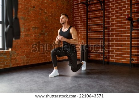 Muscular, sportive man practicing squats Royalty-Free Stock Photo #2210643571