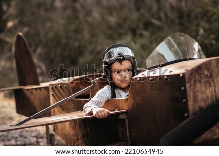 A young boy aviator in a homemade airplane in a natural landscape Authentic mood of the picture. Vintage.