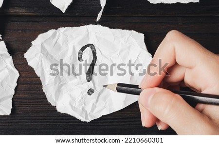 Question mark written on a piece of paper. Search for an answer. Ask a question. Royalty-Free Stock Photo #2210660301