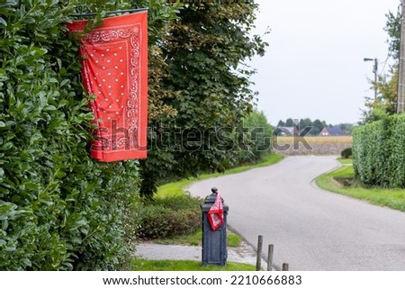 Red farmer handkerchief and flag as a farmers protests symbol in Belgiumin front of a farm. Farmers in Belgium protesting against forced shrinking of livestock because of CO2 emissions. . High quality