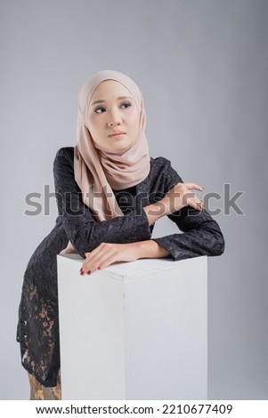 Portrait of a beautiful female model wearing hijab, a lifestyle apparel for Muslim women isolated on white background. Idul Fitri and hijab fashion concept.