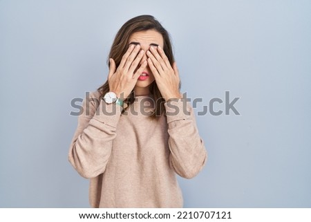 Young woman standing over isolated background rubbing eyes for fatigue and headache, sleepy and tired expression. vision problem 