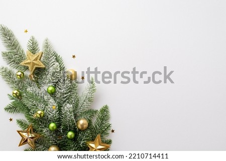 New Year concept. Top view photo of pine branch with gold and green baubles gold star ornaments and shiny confetti on isolated white background with empty space