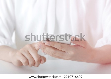 The hand of a woman operating a smartphone Royalty-Free Stock Photo #2210716609