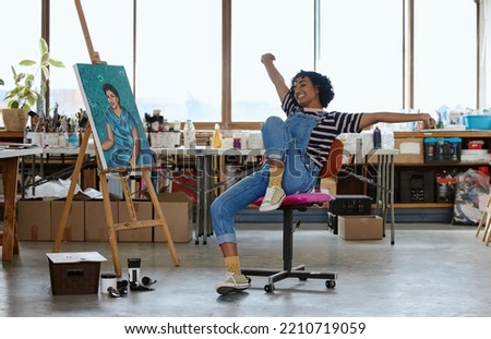 Art, happy and excited woman with painting in studio or design school smiling at finished creative project. Student from India, painter girl and celebration of completed canvas in classroom on chair.