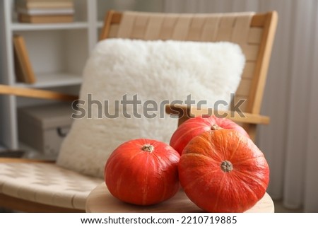 Fresh pumpkins on table in living room, closeup