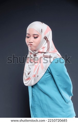 Asian hijab model over isolated studio background. Smile and posing.