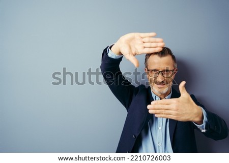 handsome business man over blue isolated background smiling making frame with hands and fingers with happy face. Creativity and photography concept.