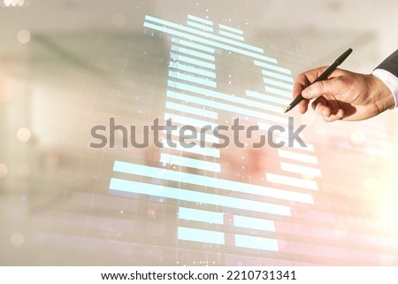 Man hand with pen working with virtual Bitcoin sketch on blurred office background. Double exposure