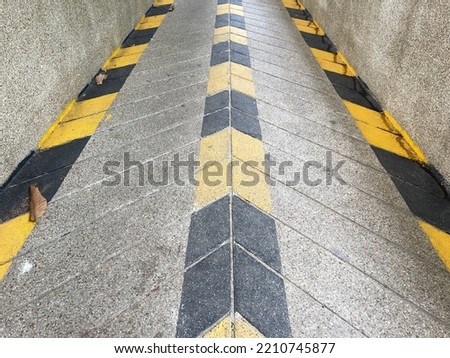 The ramp for wheelchairs going up and down the building has a yellow and black arrow symbol.