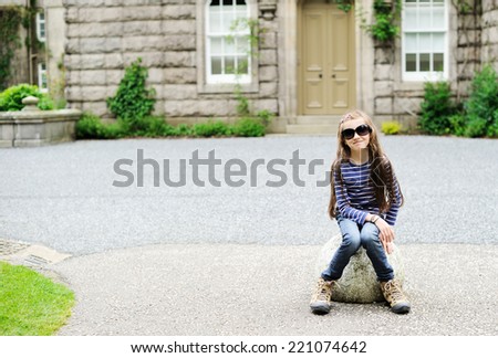 Adorable school aged girl sitting and resting during sightseeing
