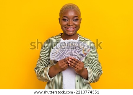 Photo of positive satisfied girl hands hold demonstrate usd banknotes income isolated on yellow color background