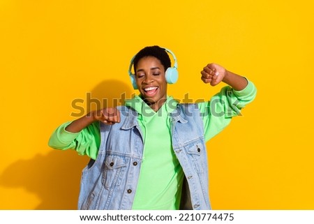 Portrait of attractive cheerful dreamy girl listening hit single dancing rest isolated over bright yellow color background