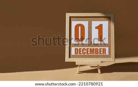 December 1st. Day 1 of month, Calendar date. Cork board, easel in sunlight on desktop. Close-up, brown background. Winter month, day of year concept.