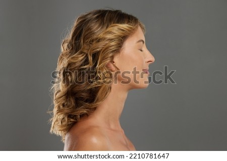 Beauty, skincare and profile of woman in studio with a wellness, health and self care lifestyle. Smooth face, healthy skin and cosmetic model with an anti aging routine standing by a gray background.