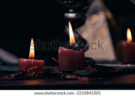 Witchcraft composition with burning candles, jewelry and pentagram symbol. Halloween and occult concept, black magic ritual. Royalty-Free Stock Photo #2210843305
