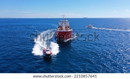 Aerial drone photo of pilot boat and huge crude oil tanker cruising in open ocean deep blue sea Royalty-Free Stock Photo #2210857641