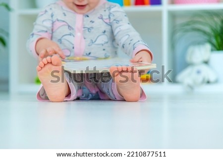 Baby is looking at a book. Selective focus. Child.