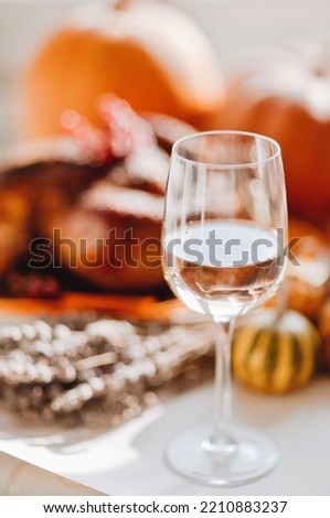 Classic USA Thanksgiving day dinner with autumn decoration. Family dining room table set with delicious golden roasted turkey on platter garnished slices of oranges and pumpkins at white background