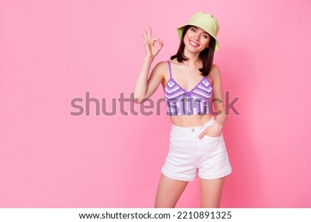 Photo portrait of gorgeous young girl show okey symbol good job feedback woman dressed trendy singlet cap isolated on pink color background