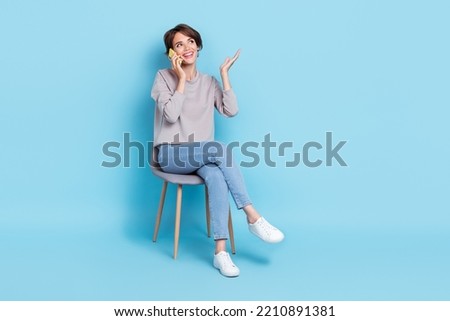 Photo of positive stylish lady office manager speak telephone modern device interested look empty space isolated on blue color background
