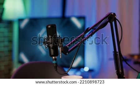 Selective focus on professional boom arm microphone stand used for recording voice in online podcast in home studio. Detail of sound device equipment used for live broadcast on internet.