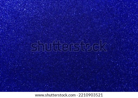 Background with sparkles. Backdrop with glitter. Shiny textured surface. Very dark blue. Mixed neon light