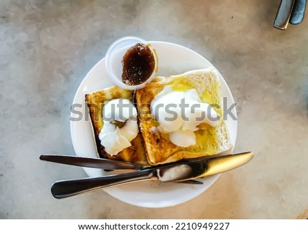 Pictures of toasted bread and half-cooked eggs, which are often referred to as 'Roti telur goyang' for Malaysians is a famous breakfast in Malaysia. 
