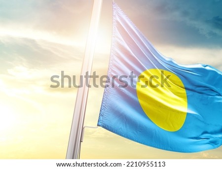 Palau national flag cloth fabric waving on the sky with beautiful sunlight - Image