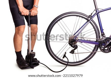 Cyclist using floor pump inflate air into a bicycle wheel. Man inflates the bicycle tire