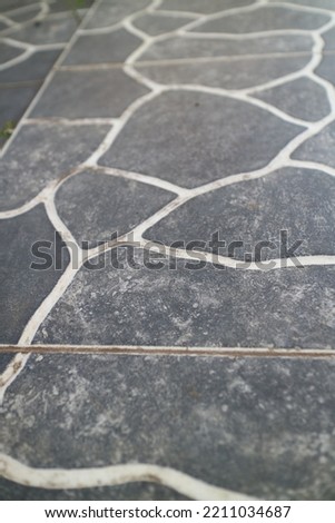 a photo of a black and white outdoor ceramic with river stone texture