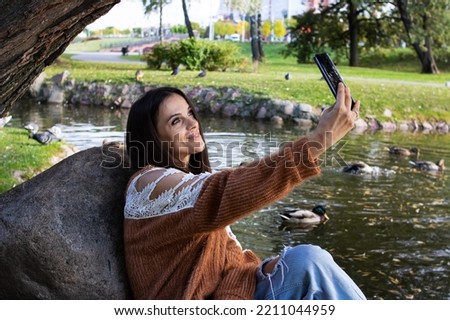 A girl on the shore of the lake makes a sephi