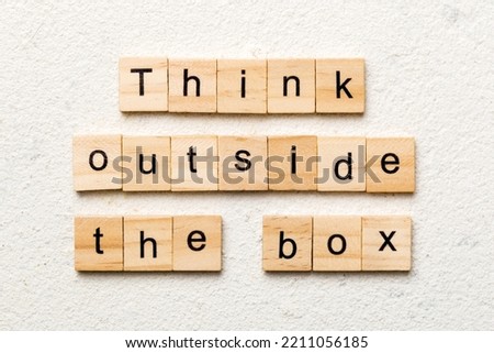 Think outside the box word written on wood block. Think outside the box text on cement table for your desing, Top view concept.