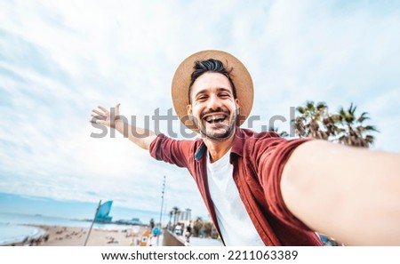 Handsome man taking selfie in Barcelona city, Spain - Happy tourist having fun walking outside on summer vacation - Travel, holidays and European landmarks concept Royalty-Free Stock Photo #2211063389