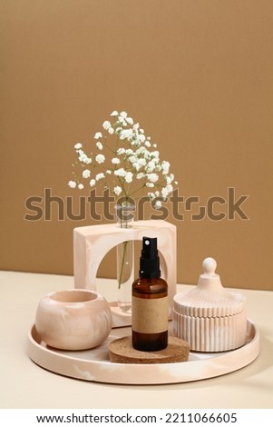 Amber glass spray bottle with modern home decor and vase of flowers. Bohemian style. Cosmetic product branding, design.