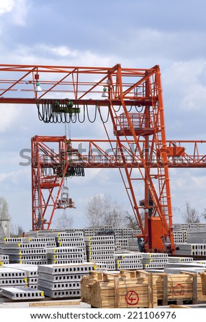 Concrete factory, construction supply business, production of concrete slabs, with crane system in background.