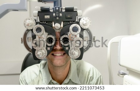 Young man examining eyes with optometrist to make glasses, professional eye exam, close-up shot at optometrist, health concept. Royalty-Free Stock Photo #2211073453