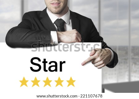 businessman in black suit pointing on white sign star golden rating vip